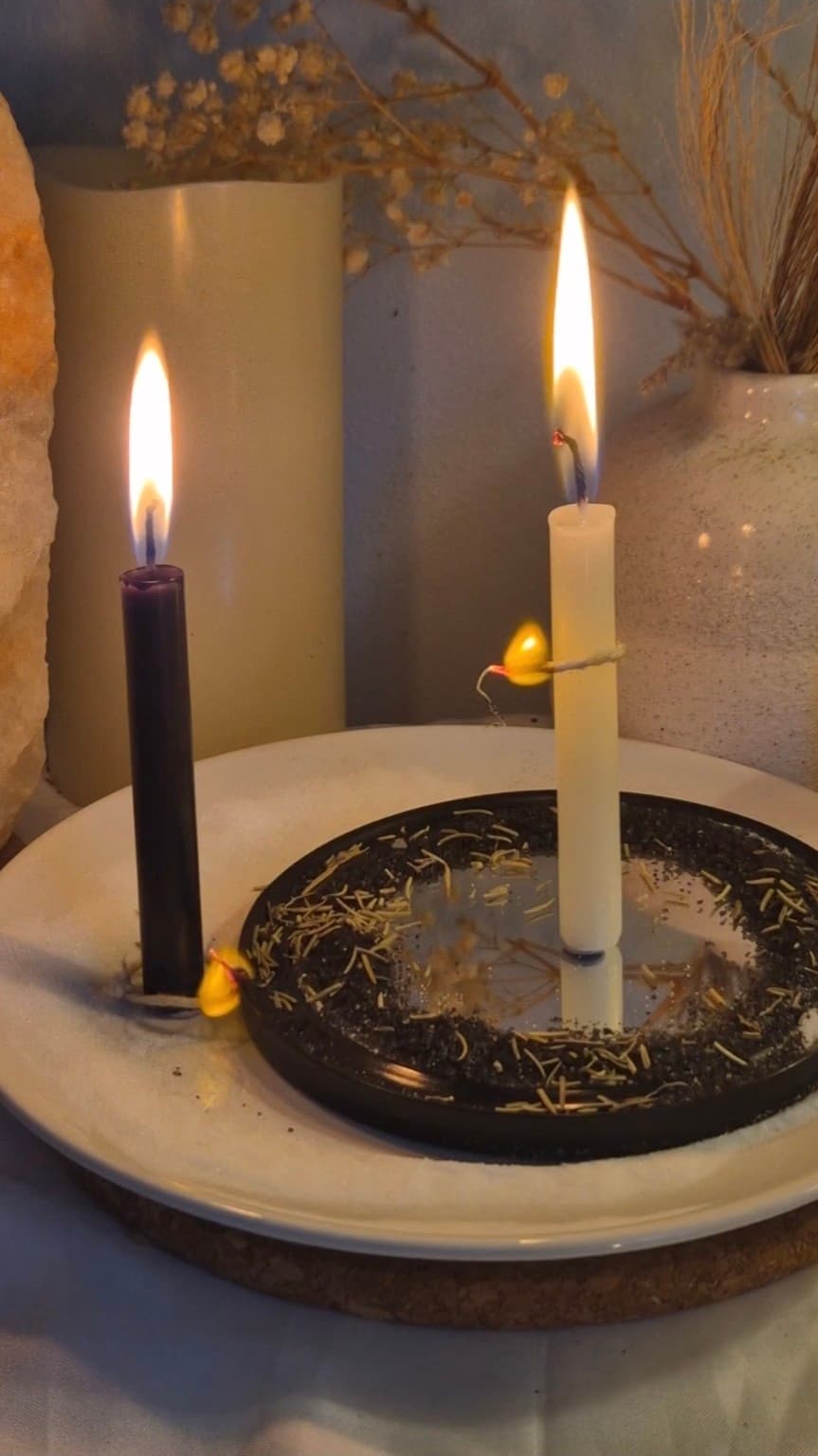 Cord separating between black and white candles during a cord cutting ritual